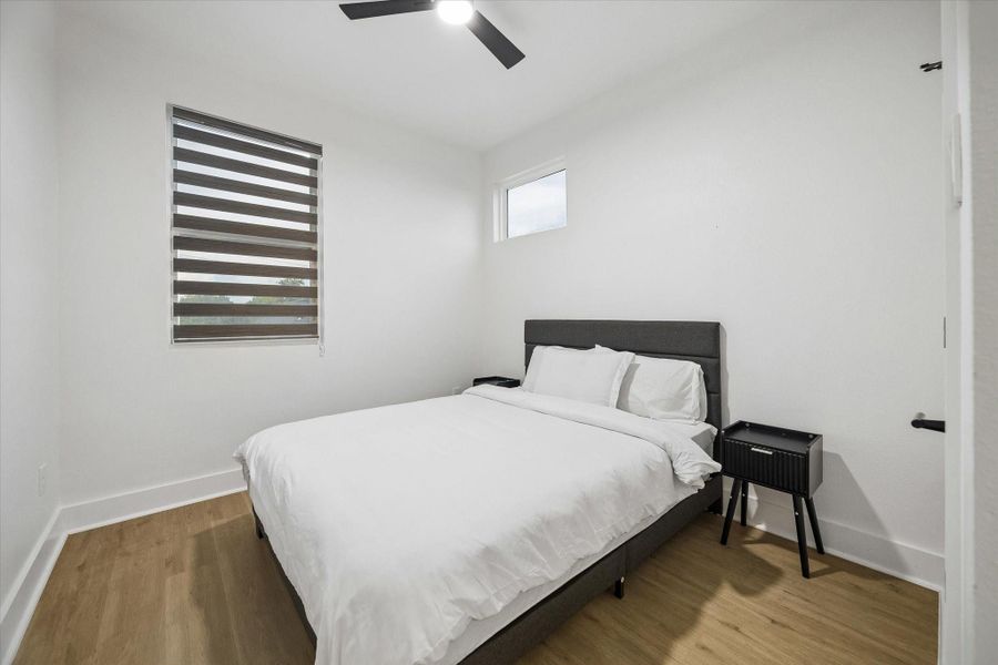 Secondary bedroom fits a queen and nightstands with walking room to spare. Plank flooring continues, and the shades are already in place. Secondary bedroom fits a queen and nightstands with walking room to spare. Plank flooring continues, and the shades are already in place.