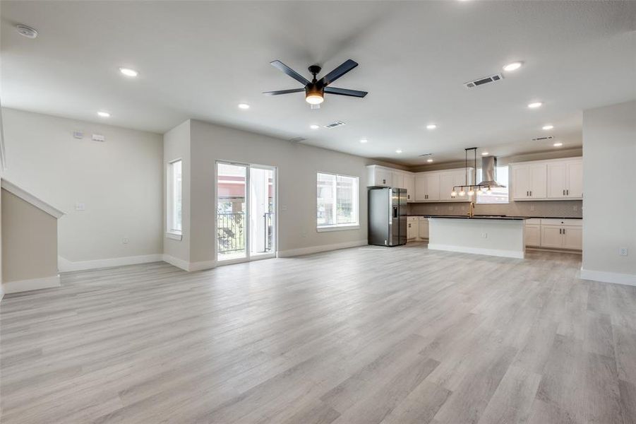Unfurnished living room with light wood-style flooring, ceiling fan, and recessed lighting