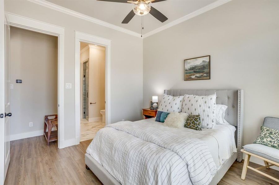 Bedroom 2 features wood-finish flooring, crown molding, and a ceiling fan with integrated lighting