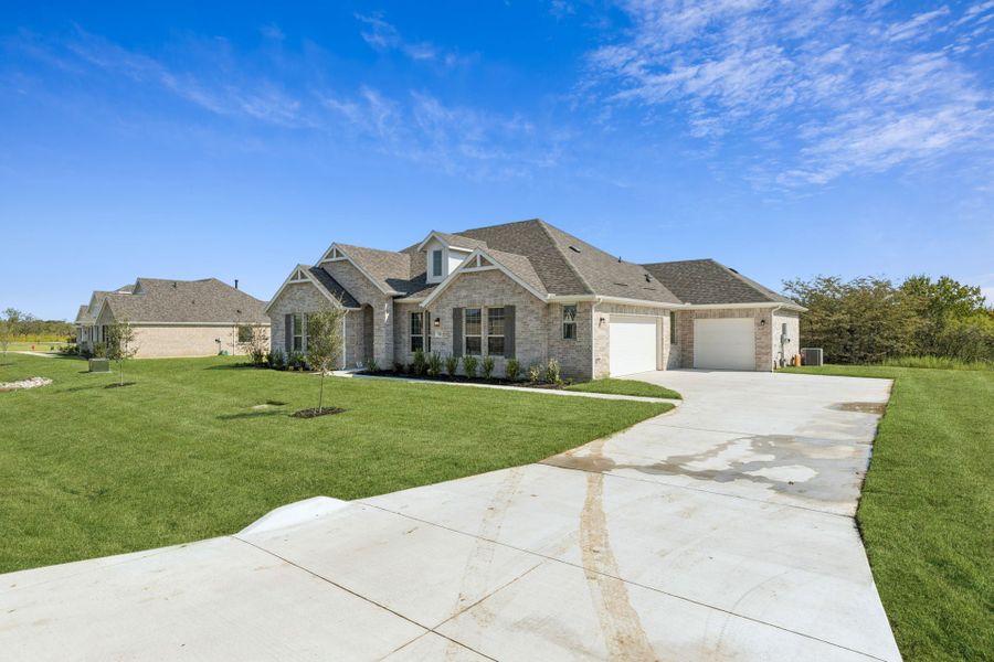 Front exterior of a new home in Ellis Ranch Estates, Waxahachie, TX, highlighting curb appeal (Image 2). Front exterior of a new home in Ellis Ranch Estates, Waxahachie, TX, highlighting curb appeal (Image 2).