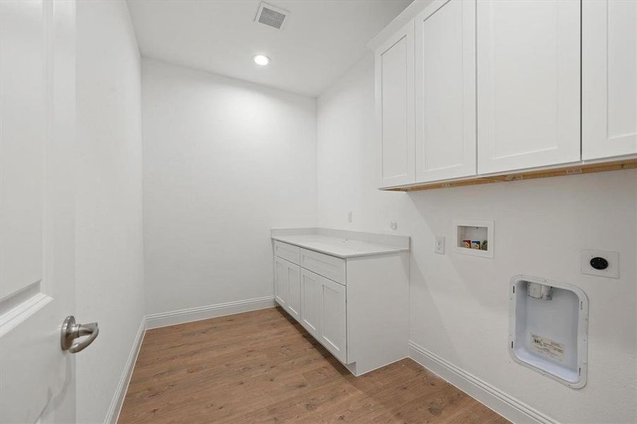 Washroom featuring cabinets, hookup for a washing machine, light wood-type flooring, and electric dryer hookup