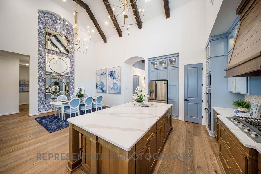 Kitchen featuring arched walkways, high vaulted ceiling, a chandelier, stainless steel appliances, and a center island Kitchen featuring arched walkways, high vaulted ceiling, a chandelier, stainless steel appliances, and a center island