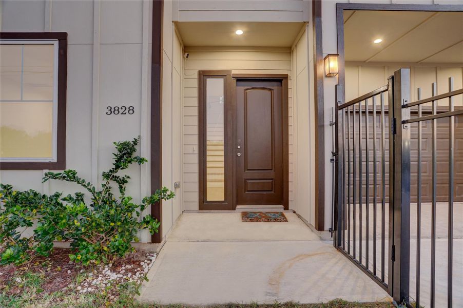 Inviting front entry with secure gated access, front, side, and backyard are fully fenced.