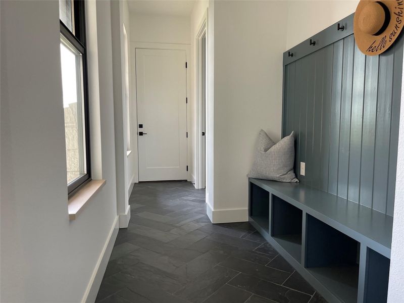 Mudroom featuring baseboards and dark marble finish floors