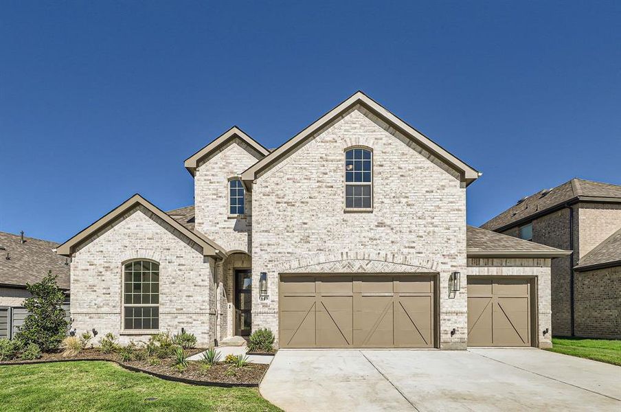 View of front of home featuring a garage and a front yard