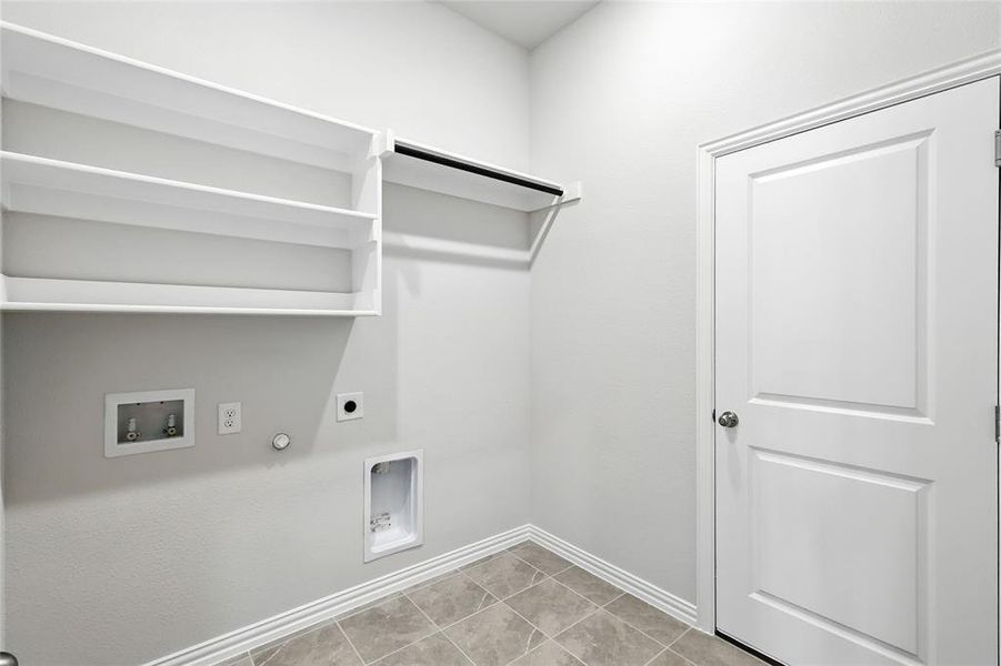 Laundry area with gas dryer hookup, electric dryer hookup, washer hookup, and light tile patterned floors Laundry area with gas dryer hookup, electric dryer hookup, washer hookup, and light tile patterned floors