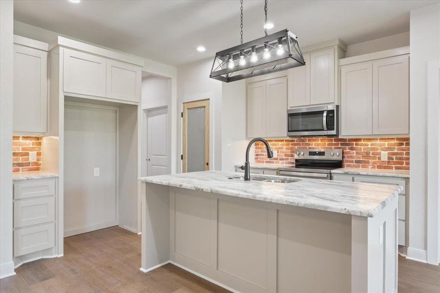 Kitchen with backsplash, stainless steel appliances, light stone countertops, light wood finished floors, and recessed lighting