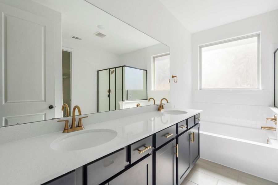 The en-suite bathroom offers a spa-like atmosphere with its elegant design, high end finishes, and tasteful lighting, creating a retreat within your own home.