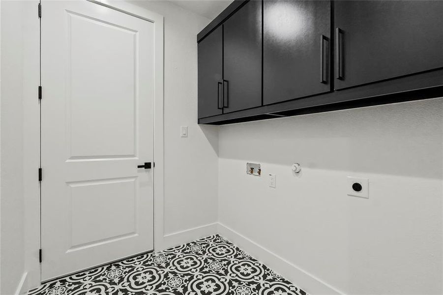 Laundry room featuring gas dryer hookup, cabinet space, tile patterned floors, hookup for a washing machine, and hookup for an electric dryer Laundry room featuring gas dryer hookup, cabinet space, tile patterned floors, hookup for a washing machine, and hookup for an electric dryer