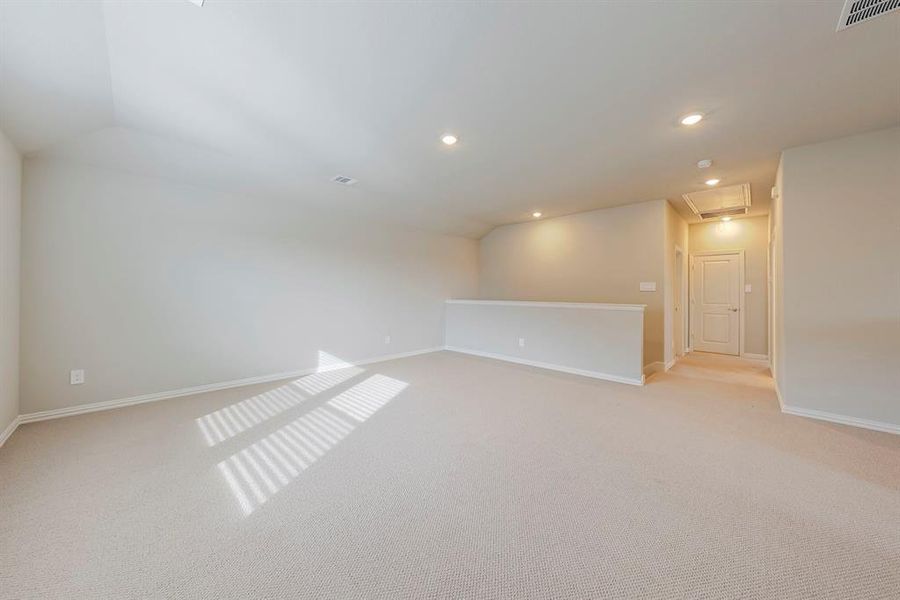 Empty room featuring light carpet, recessed lighting, and lofted ceiling Empty room featuring light carpet, recessed lighting, and lofted ceiling