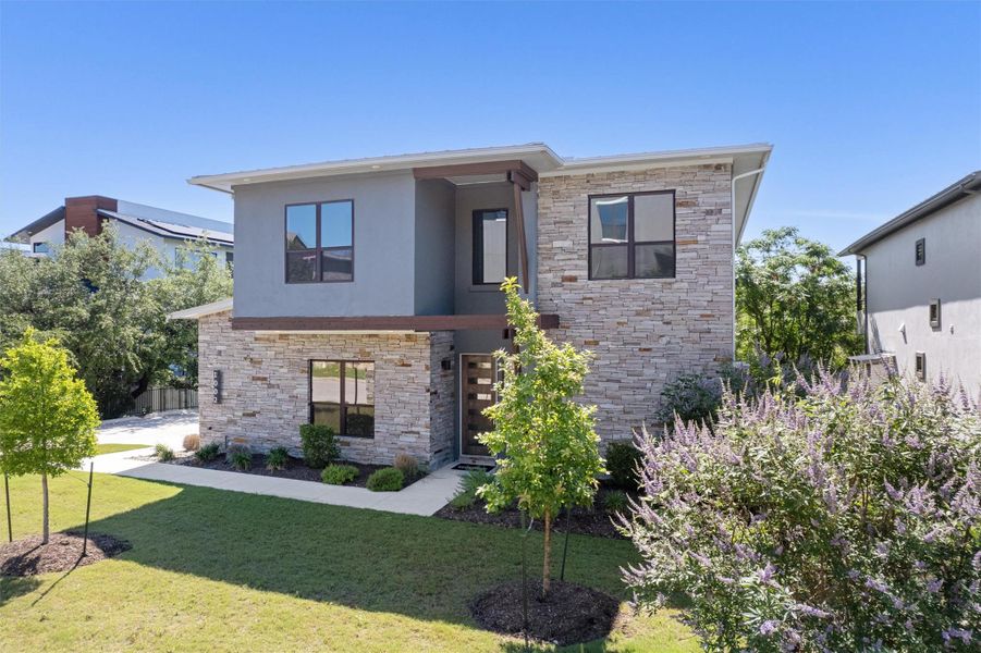 Modern architecture is showcased through clean lines, stone and stucco accents, and a well-kept front yard. Modern architecture is showcased through clean lines, stone and stucco accents, and a well-kept front yard.
