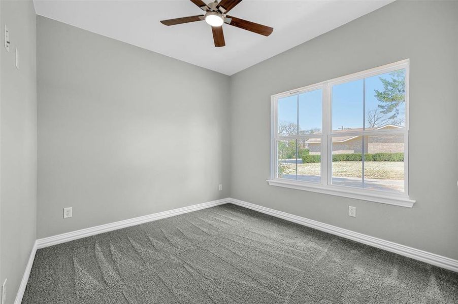 Carpeted empty room featuring ceiling fan