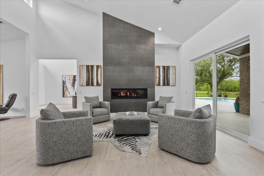 The main living area is anchored by a floor-to-ceiling modern fireplace flanked with imported Italian tile and soaring vaulted ceilings.