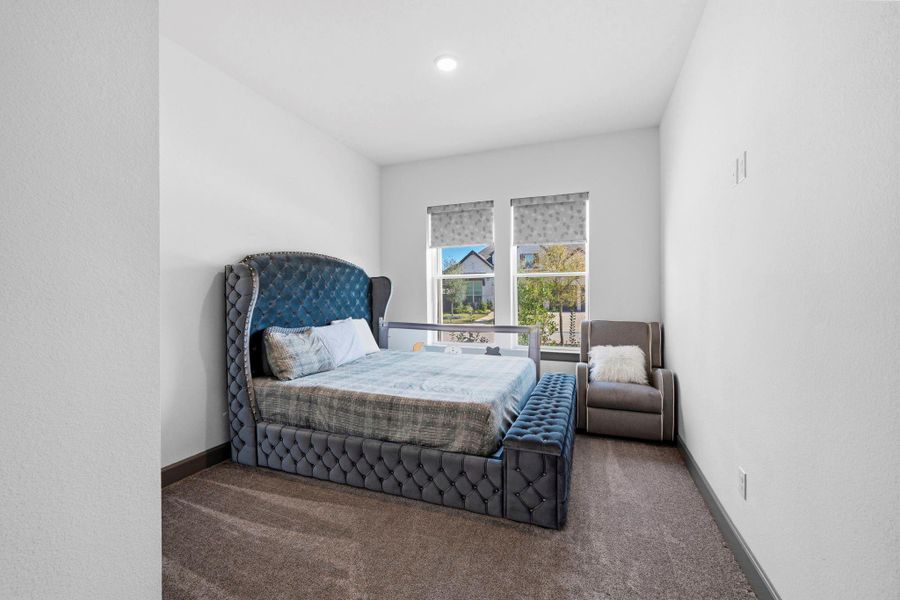 Cozy bedroom with plush carpeting, soft natural light, and a comfortable layout perfect for relaxation.