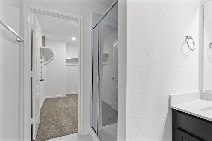 This additional view of the primary bath showcases a walk-in shower with tile surround and a separate garden tub perfect for soaking after a long day.