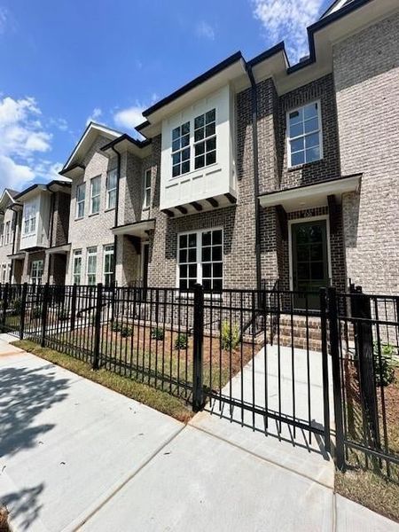 View of property featuring a fenced front yard, a residential view, and brick siding