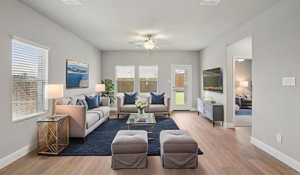 Living room featuring light wood-type flooring and a ceiling fan