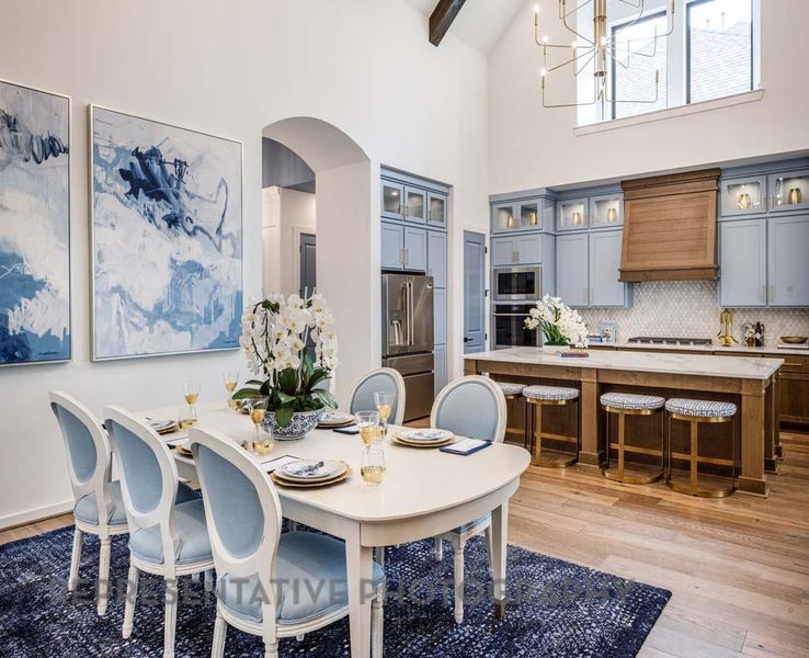 Dining room featuring high vaulted ceiling, light wood-style floors, arched walkways, a chandelier, and beam ceiling Dining room featuring high vaulted ceiling, light wood-style floors, arched walkways, a chandelier, and beam ceiling