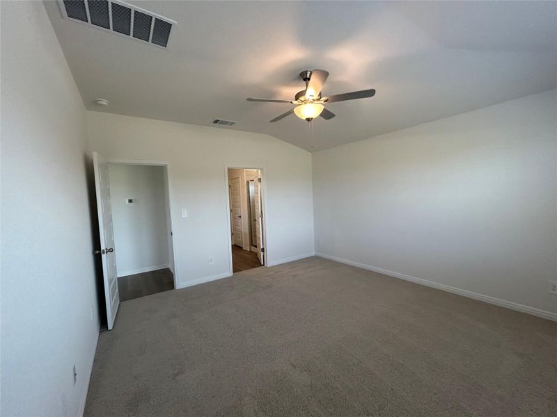 Unfurnished bedroom with lofted ceiling, carpet, and a ceiling fan Unfurnished bedroom with lofted ceiling, carpet, and a ceiling fan