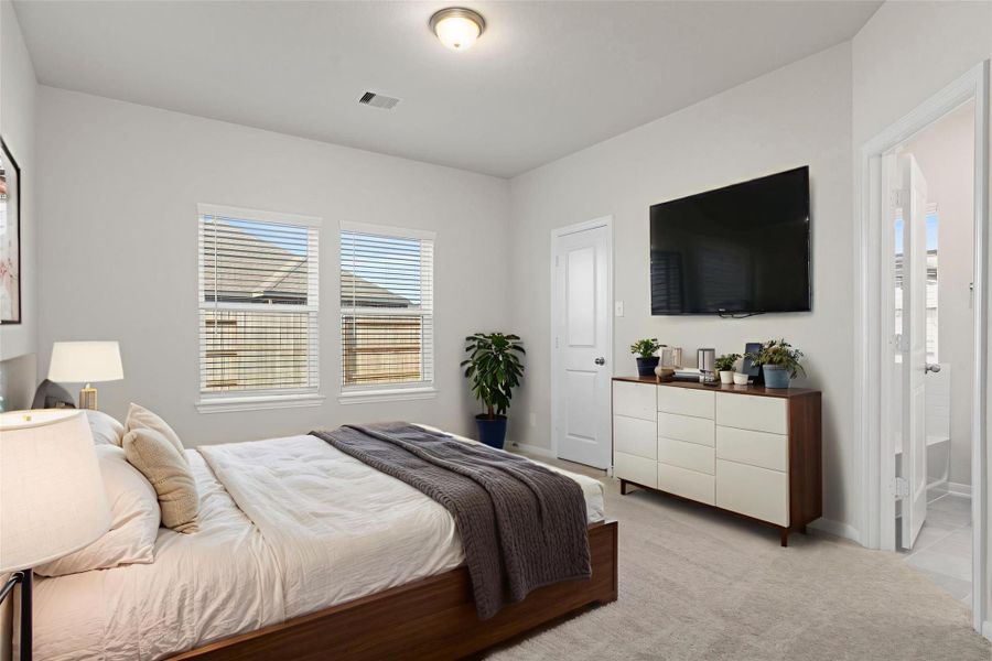 Virtually staged, this primary bedroom offers a serene retreat with plush carpeting, soft tones, and abundant natural light. The room comfortably accommodates a full furniture set while maintaining an open, airy feel.