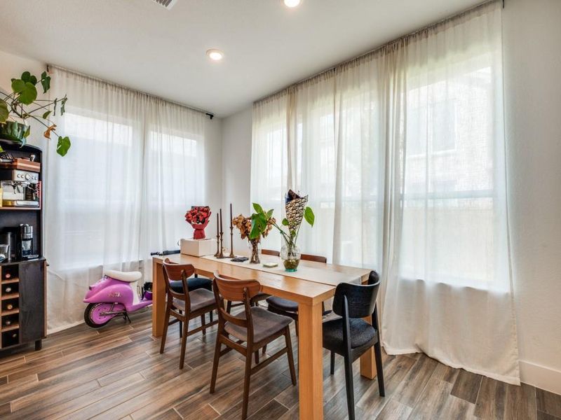 Dining area with wood finished floors and recessed lighting