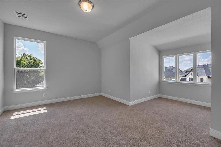 Unfurnished room with vaulted ceiling and carpet floors