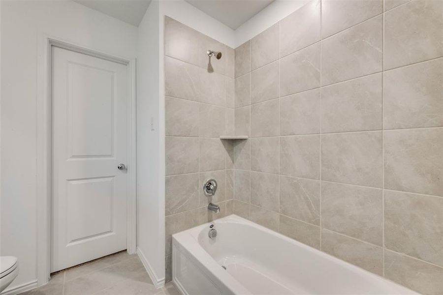 Bathroom with tub / shower combination and light tile patterned flooring Bathroom with tub / shower combination and light tile patterned flooring