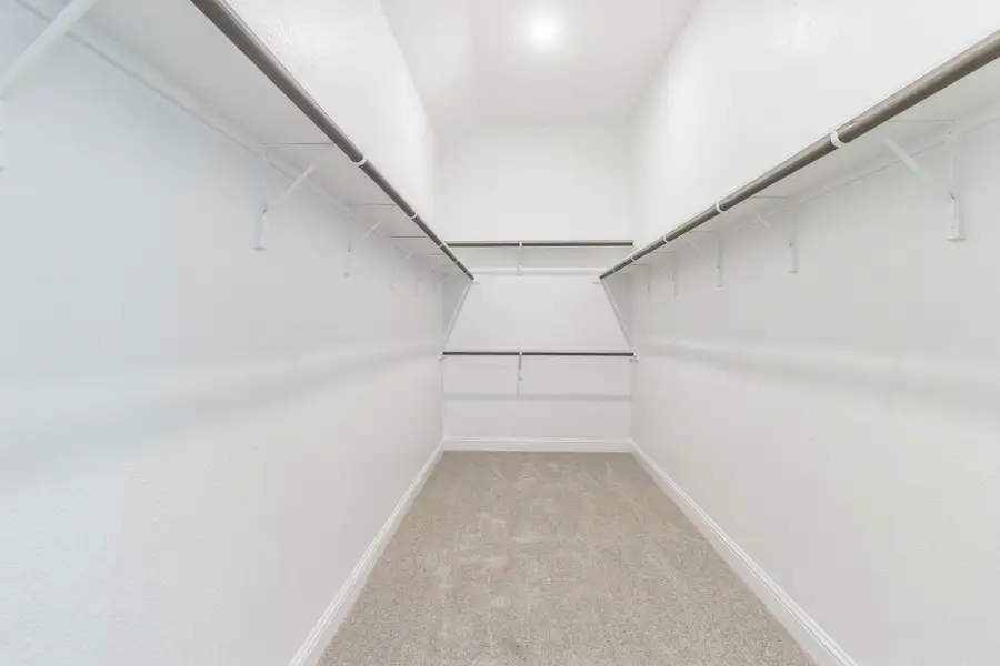 Walk in closet featuring light carpet