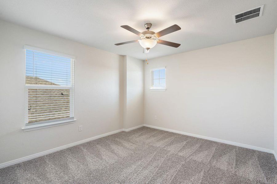 Bright and airy bedroom with carpet flooring and ceiling fan, ideal for family or guests. Bright and airy bedroom with carpet flooring and ceiling fan, ideal for family or guests.