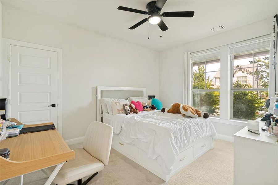 Bright interior space featuring a multi-pane window, flush-panel door, and a ceiling fan with integrated lighting