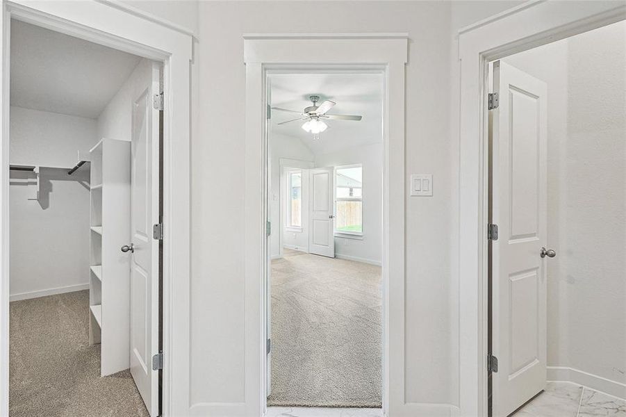 Corridor featuring light colored carpet