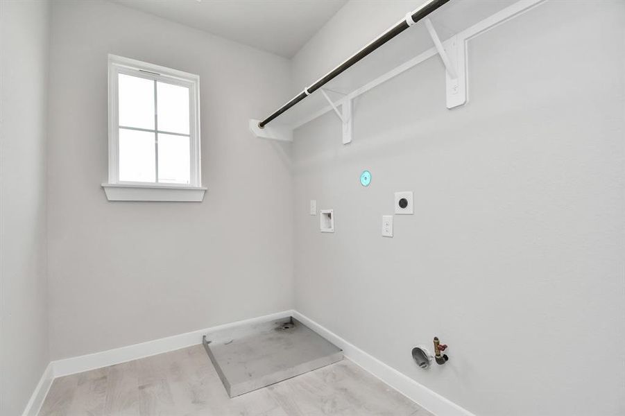 A stylish laundry room where practicality meets a contemporary aesthetic. The dark finishes lend a sophisticated touch, creating a space that is both functional and visually appealing. Both electric and gas connections available. Sample photo of completed home with similar floor plan. Actual colors and selections may vary.