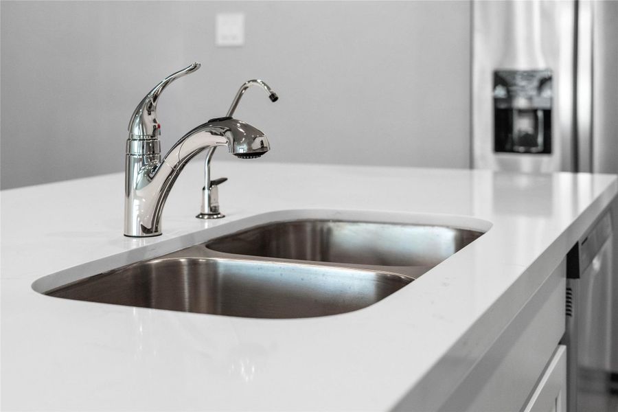 The kitchen features a stainless steel 50/50 undermount sink and a Moen Integra chrome kitchen faucet with DuPure water filtration system.