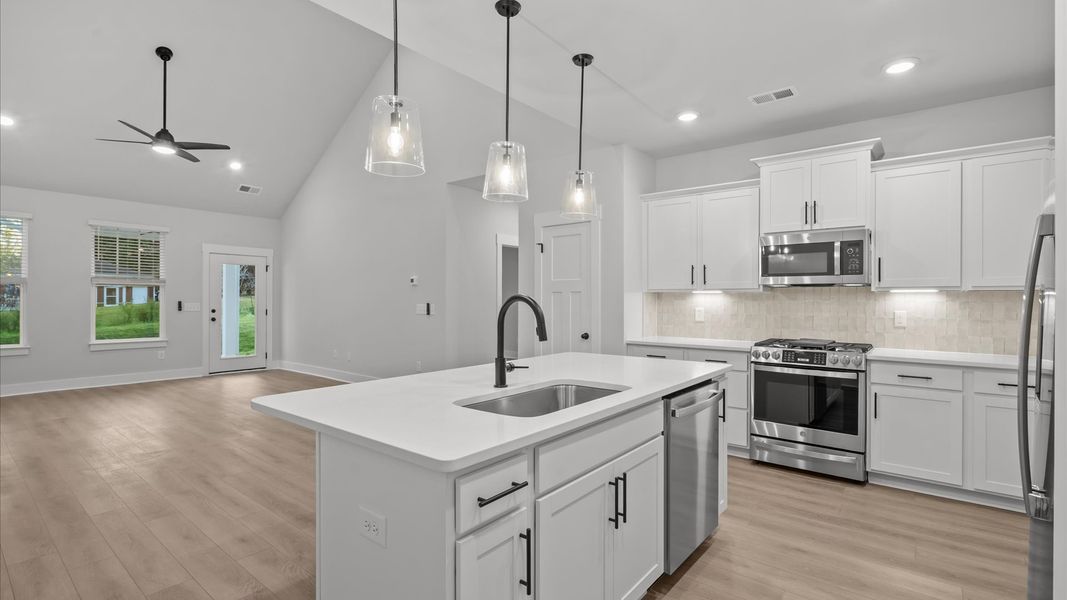 Highly skilled craftsmanship shines in this modern kitchen with pendant lighting and a central island focal point Highly skilled craftsmanship shines in this modern kitchen with pendant lighting and a central island focal point