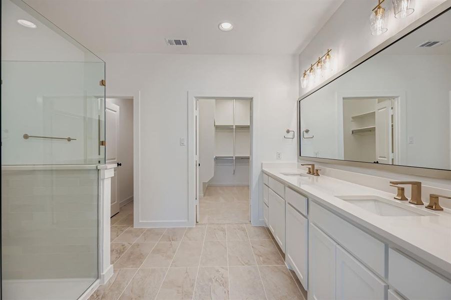 Bathroom featuring a stall shower, double vanity, recessed lighting, and a walk in closet Bathroom featuring a stall shower, double vanity, recessed lighting, and a walk in closet
