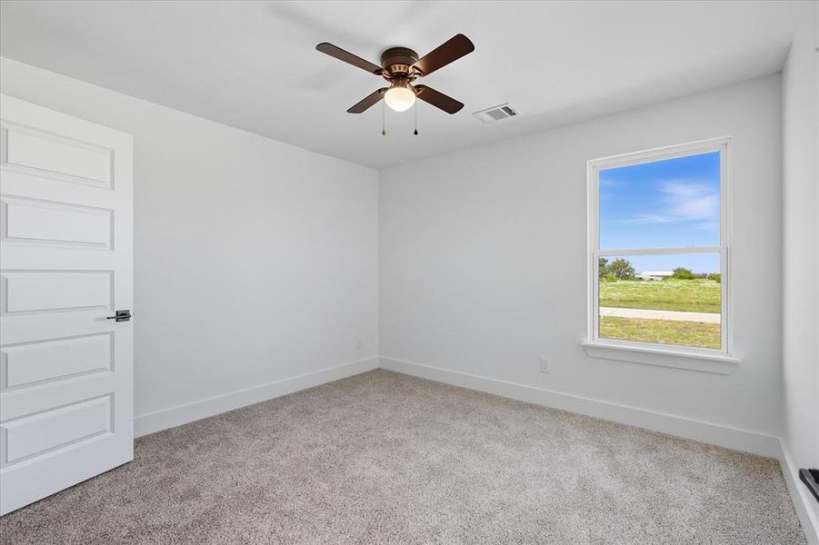 Unfurnished room featuring light colored carpet and ceiling fan