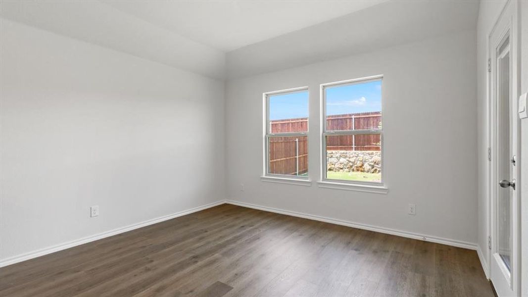 Bright interior space featuring wood-finish flooring, white baseboards, and neutral wall tones