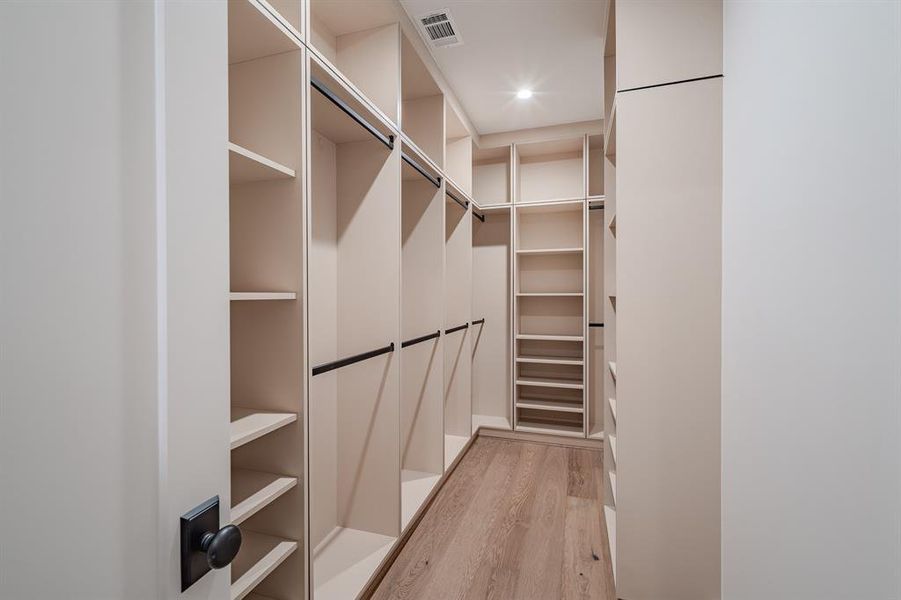 Walk in closet featuring light wood-style floors Walk in closet featuring light wood-style floors