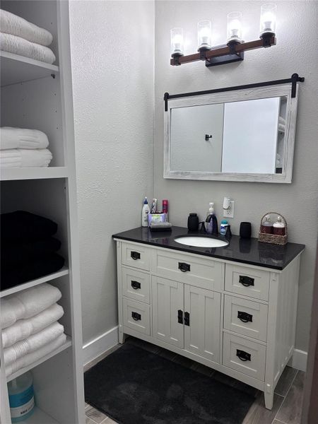 Master Bathroom with a textured wall, vanity, and wood tiled floors