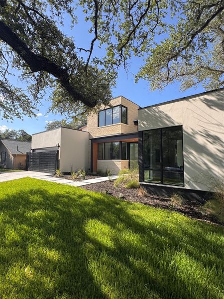 A modern architectural marvel stands amidst mature trees, showcasing clean lines and abundant natural light.