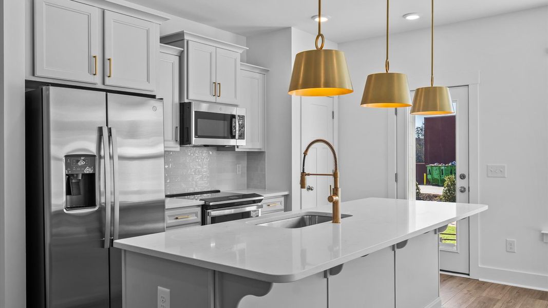 First-class kitchen with a spacious 9-foot island perfect for entertaining beneath designer pendant lighting