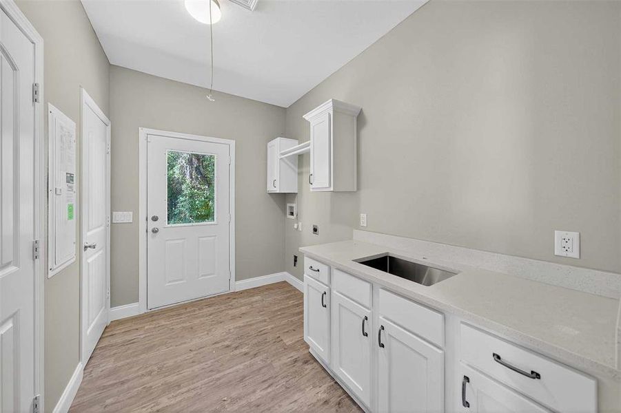 Laundry area featuring cabinet space, light wood-type flooring, washer hookup, and hookup for an electric dryer