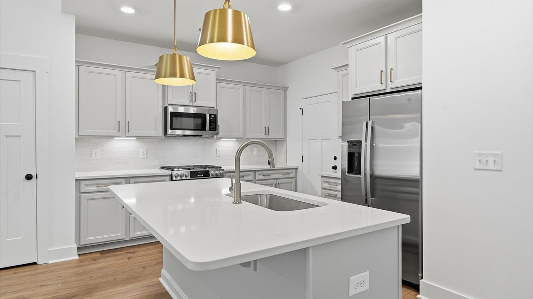 Memorable meals begin in this vibrant kitchen with pendant lighting and a thoughtfully designed island by DRB Homes Memorable meals begin in this vibrant kitchen with pendant lighting and a thoughtfully designed island by DRB Homes