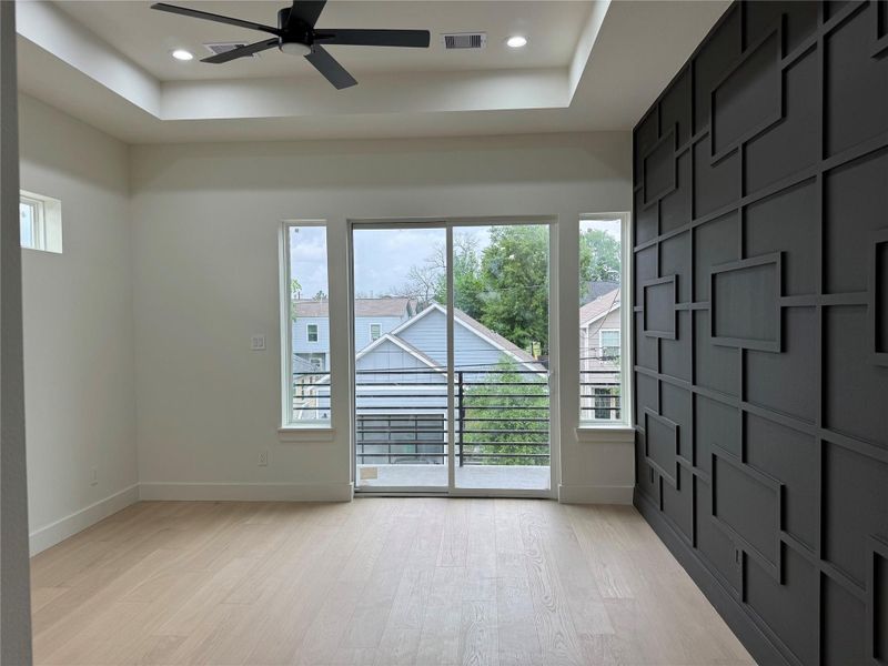 Primary Bedroom with Accent Wall and Balcony