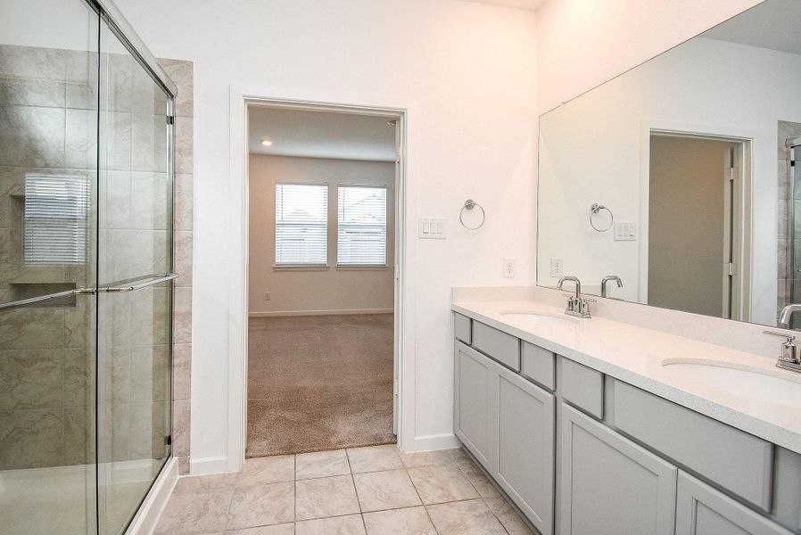 PRIMARY WALK IN SHOWER, TILE FLOORING AND A WALL OF STORAGE SHELVES