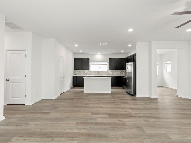 An open floorplan seamlessly connects the well-appointed kitchen with stainless steel appliances and generous counter space.