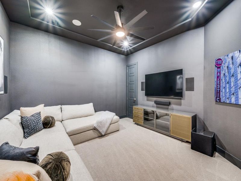 Carpeted living room with ceiling fan