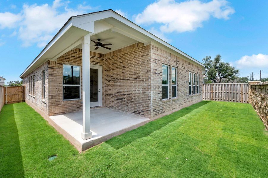 Back of property featuring ceiling fan, brick siding, a fenced backyard, and a patio