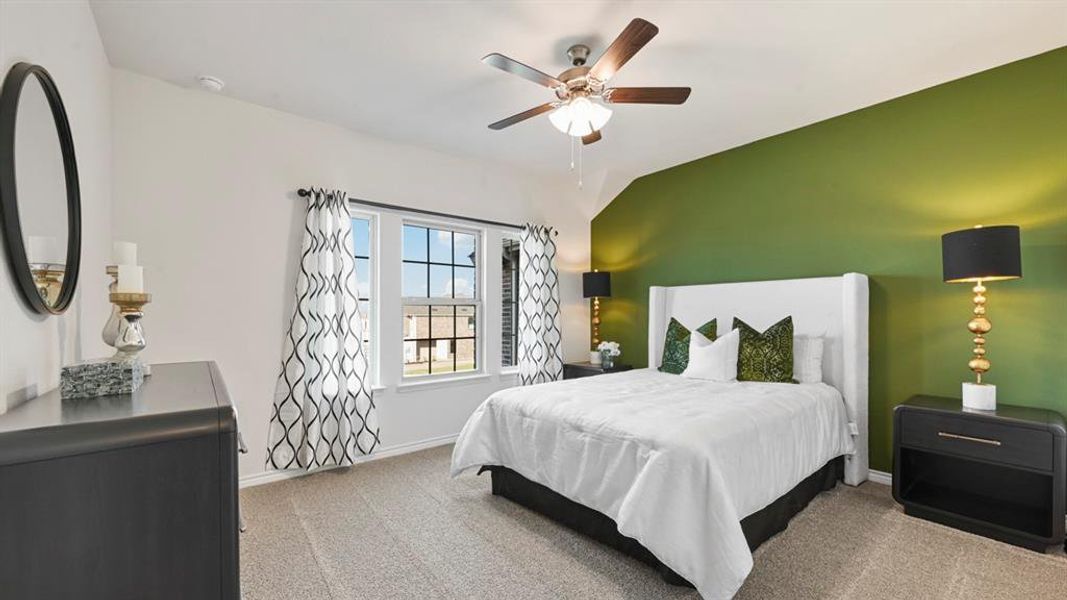 Bedroom featuring ceiling fan, carpet floors, and vaulted ceiling