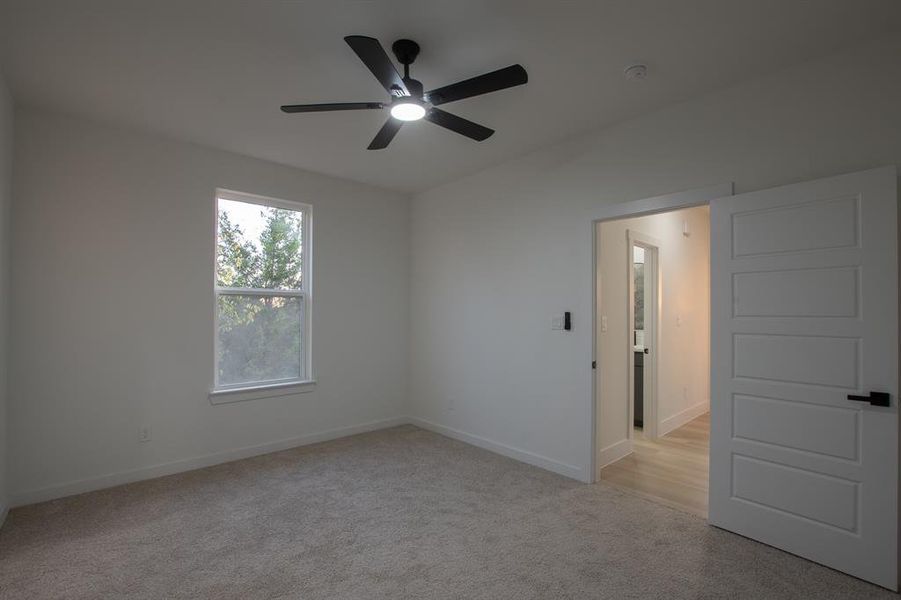 Unfurnished room featuring a towering ceiling, ceiling fan, a raised ceiling, and light wood-type flooring